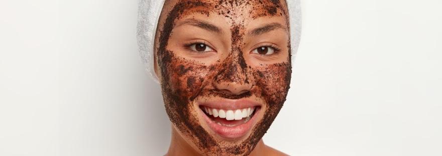 Beautiful girl with coffee face mask and beautiful smile
